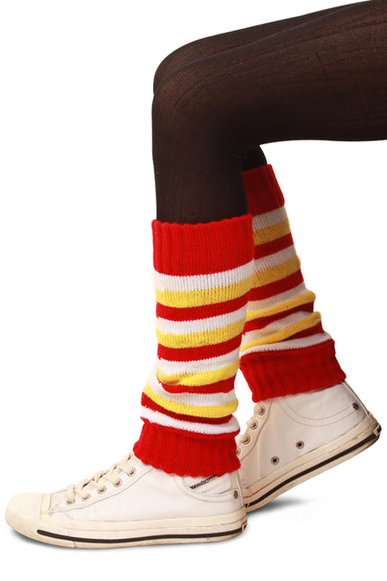 Beenwarmers voor kind met brede strepen in rood, wit en geel, gedragen over een donkere legging bij sneakers