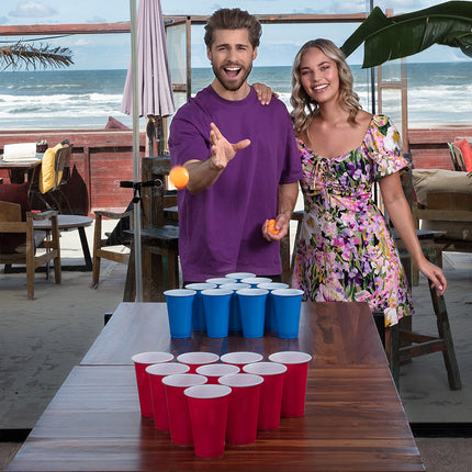 Beer pong opstelling met twee driehoeken bekers op tafel tijdens een feest