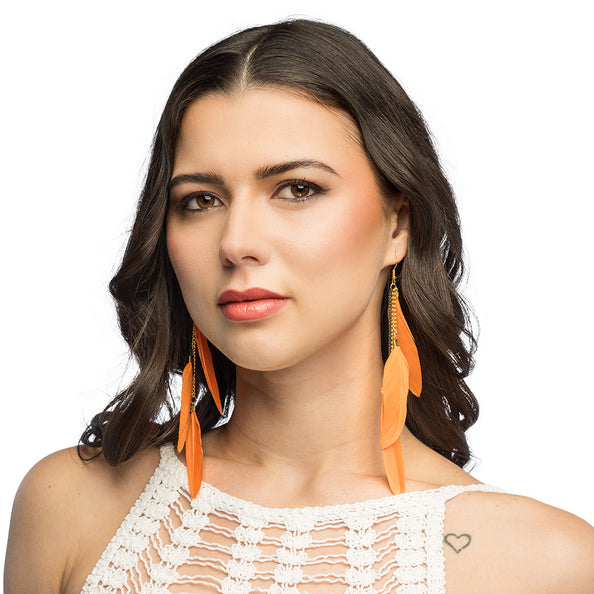 Boho verenoorbellen oranje gedragen bij los donker haar en een wit gehaakt topje, voor een hippiefeest