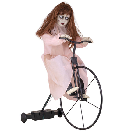 Cycling Cindy animatronic: spookmeisje in roze jurk op zwart hoogwielfietsje voor Halloween