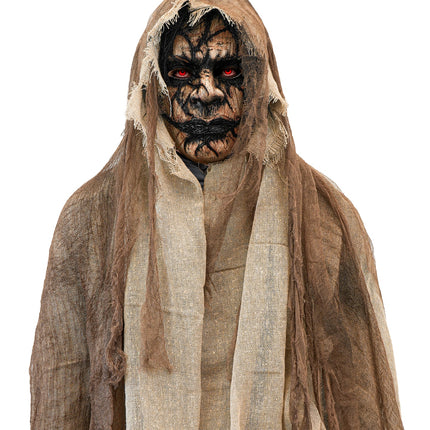 Detail van demonenmasker met cape: verweerd gezicht met rode ogen onder de kap