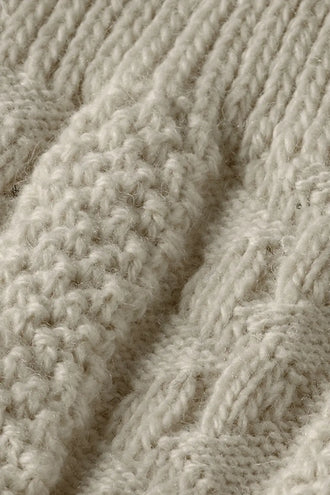 Detail van het gebreide kabel- en noppenpatroon van de off white Tiroler kniekousen