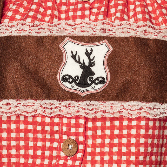 Detail van het hertenembleem op de bruine bib met crème kanten bies en kokosknoop
