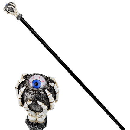 Detail van de skelet stok: benige vingers rond een grijze bol met blauw oog en rode adertjes