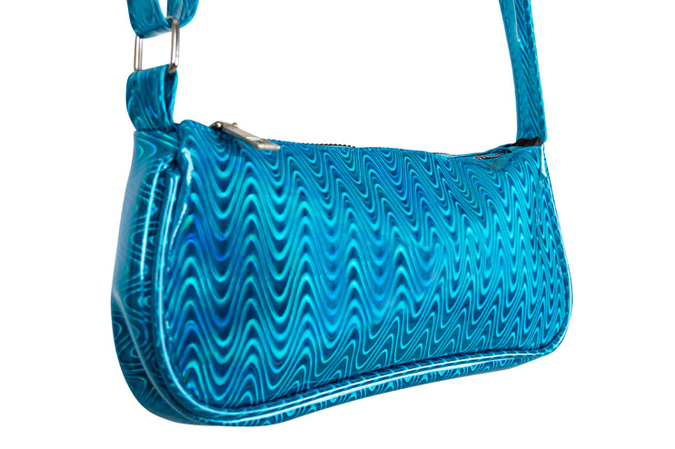 Detail van het turquoise tasje met glanzend golfpatroon, rits en metalen schuifgesp op de band