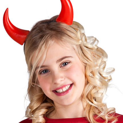 Duivel hoorntje op haarband gedragen door een kind, rode hoorntjes rechtop in blond haar, voor Halloween