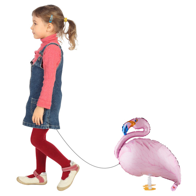 Folieballon wandelende flamingo aan een koord achter een kind, als loopballon voor een kinderfeestje