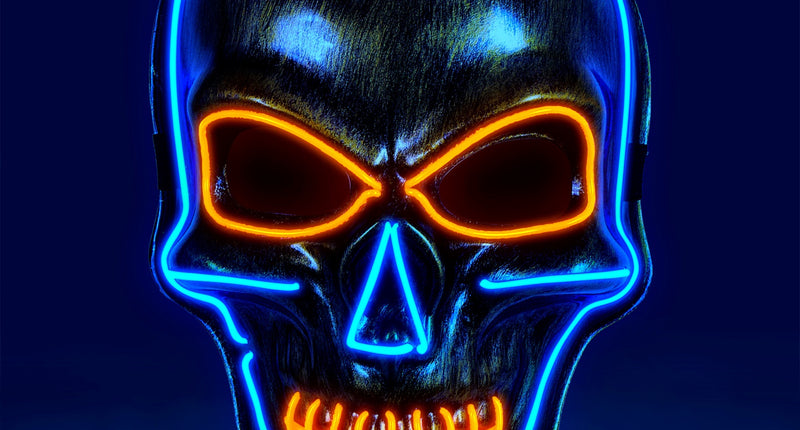 Gouden schedel masker met gekleurd ledlicht, blauwe omtrek en oranje ogen en gebit in het donker