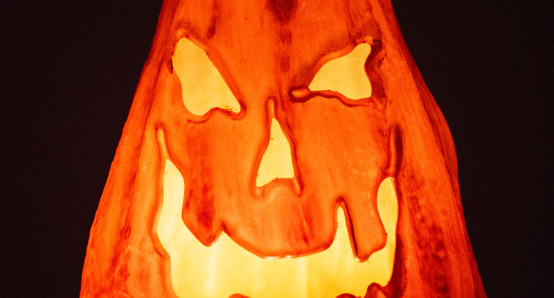 Grijnzende pompoen met vlammend lichteffect, oranje oplichtend grijnsgezicht in het donker met Halloween
