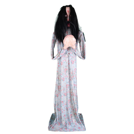 Halloween animatronic Beatrice met nephersenen in beide handen, opgericht in bloemetjesjurk