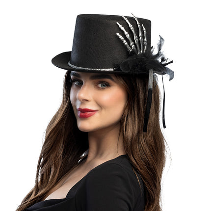 Halloween hoed met skelet hand, zwart met zilveren band en veren, gedragen door dame