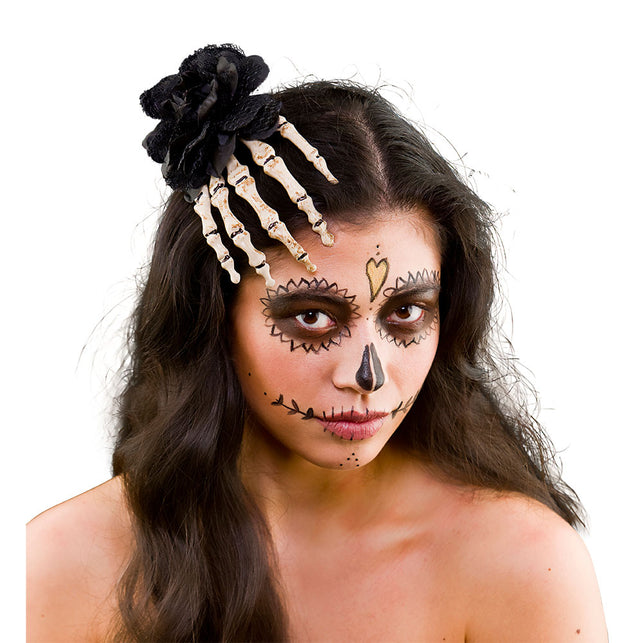 Hand skelet haarclip met zwarte roos in donker haar, gedragen bij een sugar skull-look voor Halloween