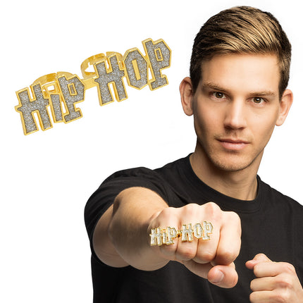Hiphop ring goud met glitterletters HIP HOP over twee vingers van een vuist, voor een foute party