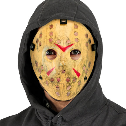 Hockeymasker killer onder zwarte capuchon, alleen het vergeelde gele masker zichtbaar