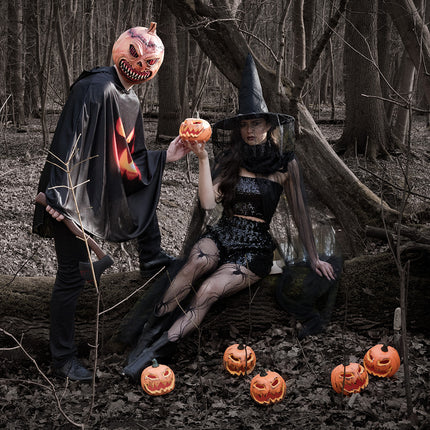 Hoofdmasker Pumpkin monster gedragen met zwarte cape in een herfstbos tijdens Halloween