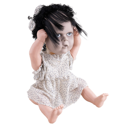 Horrorpop meisje zittend met sluike haarlok over het gezicht, griezelige babypop