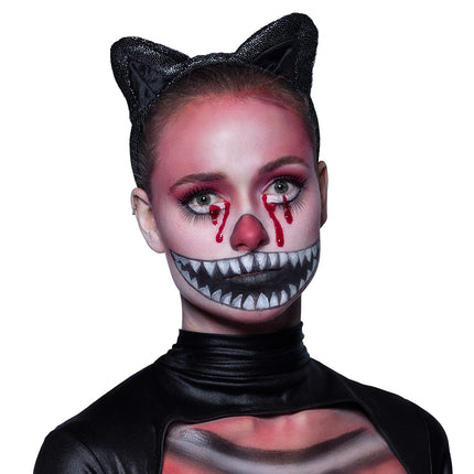 Kattenlook met witte tandengrijns, rood neusje en bloeddruppels geschminkt met de schminkset Crazy cat voor Halloween