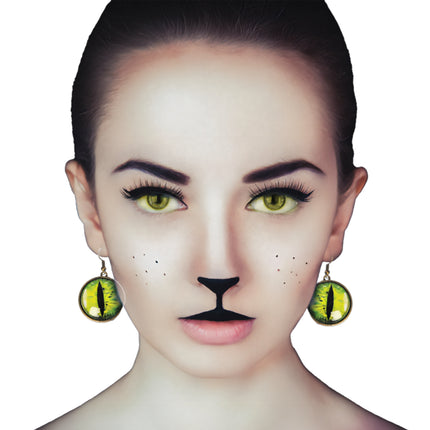 Kattenogen oorbellen geel met groene iris en zwarte spleetpupil, gedragen bij een kattenlook voor Halloween