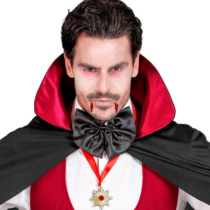 Ketting Dracula medaillon over rood vest, rood lint zichtbaar in de hals bij griezelschmink