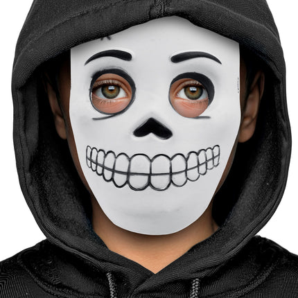 Kind draagt wit schedelmasker met open oogopeningen onder zwarte capuchon