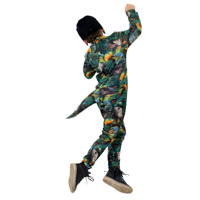 Kind springt in hagedis jumpsuit, staart zwaait mee tijdens een dierenfeest