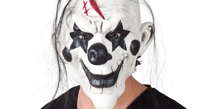 Latex hoofdmasker psycho clown met wit gezicht, zwarte sterogen, lang zwart haar en mini hoedje voor Halloween