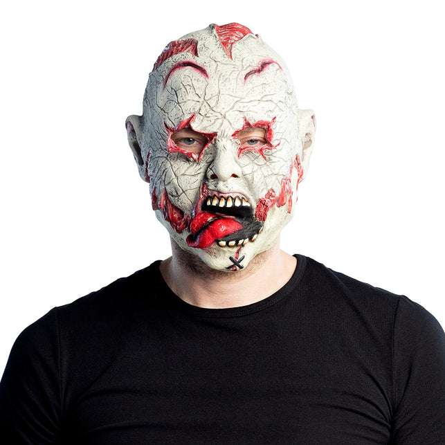 Latex hoofdmasker Undead gedragen door man, bleek zombiehoofd met open wonden en rode tong, voor Halloween
