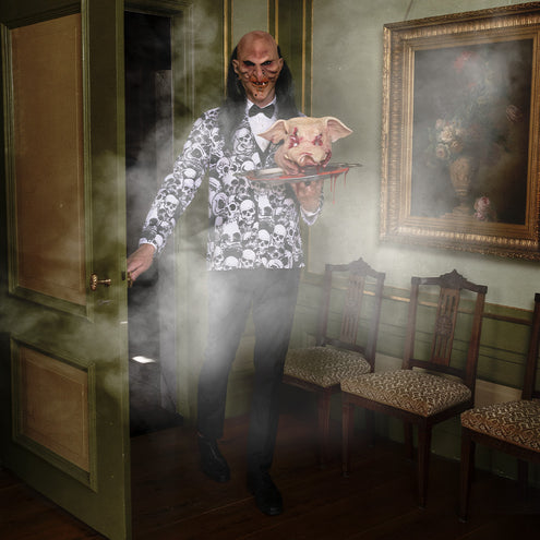 Latex varkensmasker met druipend nepbloed op een presenteerblad tijdens een Halloweenavond
