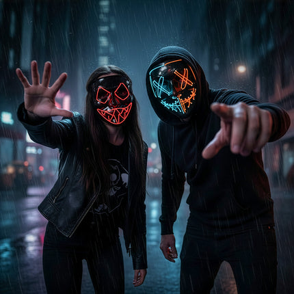 LED masker Killer smile duo blauw en oranje verlicht onder een zwarte capuchon in een regenachtige straat