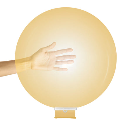 Mega ballon latex opgeblazen in crèmegeel, met hand ernaast als maatvergelijking en ballonklem onderaan