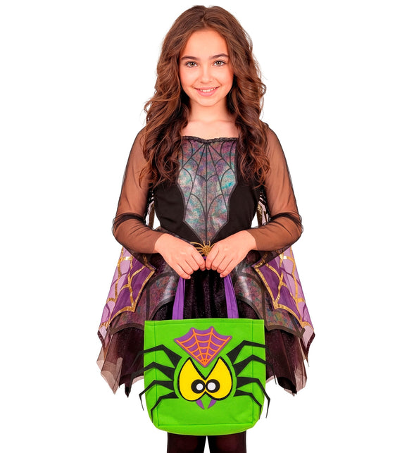 Meisje met groene trick-or-treat tas spin bij een spinnenwebjurk