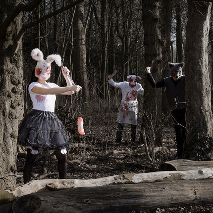 Mes Slasher in de hand van een gemaskerde horrorfiguur in een donker bos tijdens Halloween