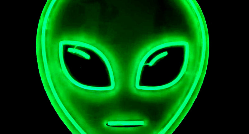 Neon licht alien in groen, ovaal alienhoofd met grote schuine ogen en mondstreep als lichtlijnen
