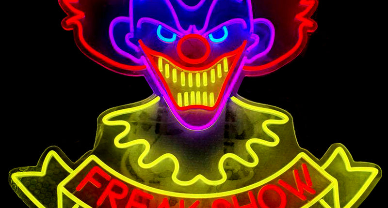 Neonbord clown Freak Show met blauwe kop, rode haarplukken en geel lint, voor Halloween