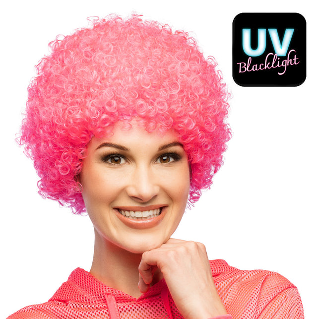 Neonroze afropruik met kleine krullen, gedragen door vrouw, met uv blacklight-effect