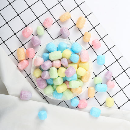 Pastelkleurige foamvlokjes voor ballonnen op een wit schaaltje als feesttafeldecoratie