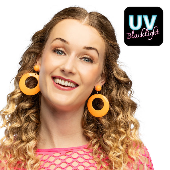 Retro oorbellen neonoranje met grote ronde hanger gedragen door een vrouw met lange krullen, voor een neon party