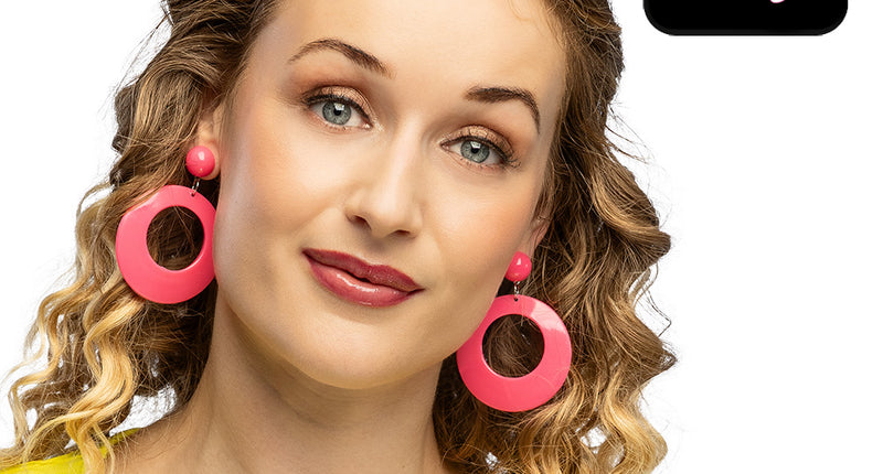 Retro oorbellen neonroze met open ronde hangers gedragen bij een geel netshirt voor een jaren 80-feest