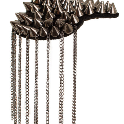 Schouderstuk met spikes van dichtbij, zwarte ondergrond met rijen studs en franje van kettinkjes