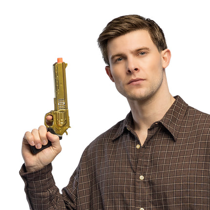 Speelgoedpistool Golden viper gouden revolver met zwarte greep omhoog gehouden door een man voor een westernfeest