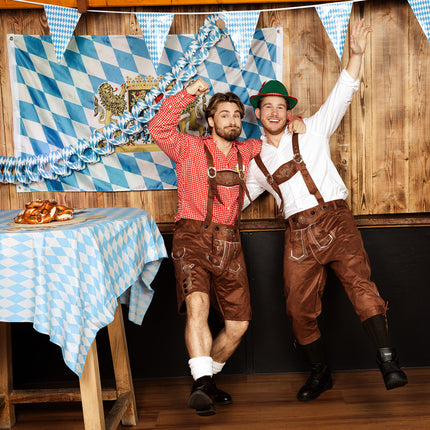 Tiroler kostuum heren met rood-wit geruit shirt op een Oktoberfest met Beierse vlag