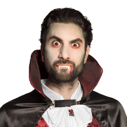Vampiertanden gedragen met bloedspoor langs de mondhoek voor een Halloween vampierlook