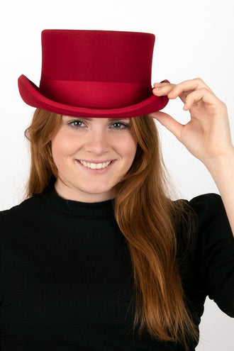 Vrouw met rode hoge hoed van wolvilt op een themafeest, hand aan de rand
