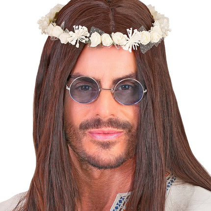 Witte bloemenkrans over lang bruin haar bij een hippieoutfit voor heren
