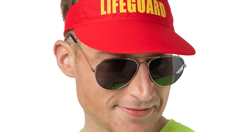 Zonneklep badmeester Bart in het rood met geel opschrift, gedragen door een man op een strandfeest