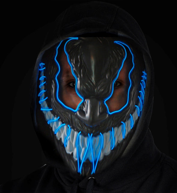 Zwart monster masker met blauwe lichtdraden en witte tanden, gedragen op een donker horrorfeest